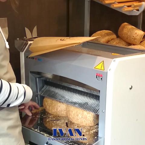 Broodsnijmachine Jac ECO PLUS in werking en bediend door de bakkerin