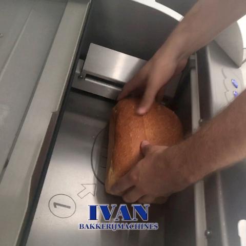 Een persoon stopt een brood in de broodsnijmachine Jac VARIA SELF